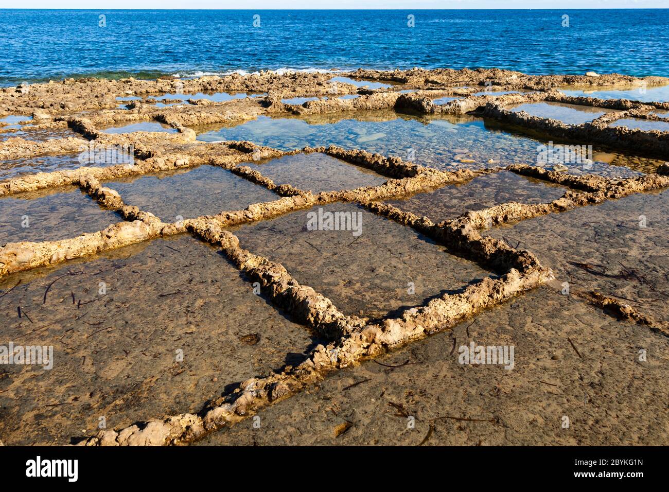 Gozo Sea Salt Production in Żebbuġ, Malta. The old salt pans are worked only from May, when the power of the sun becomes stronger Stock Photo