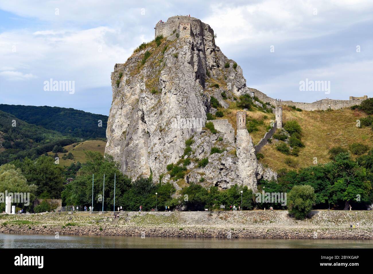 Slovakia, unidentified people walking along Danube river with medieval castle Devin Stock Photo