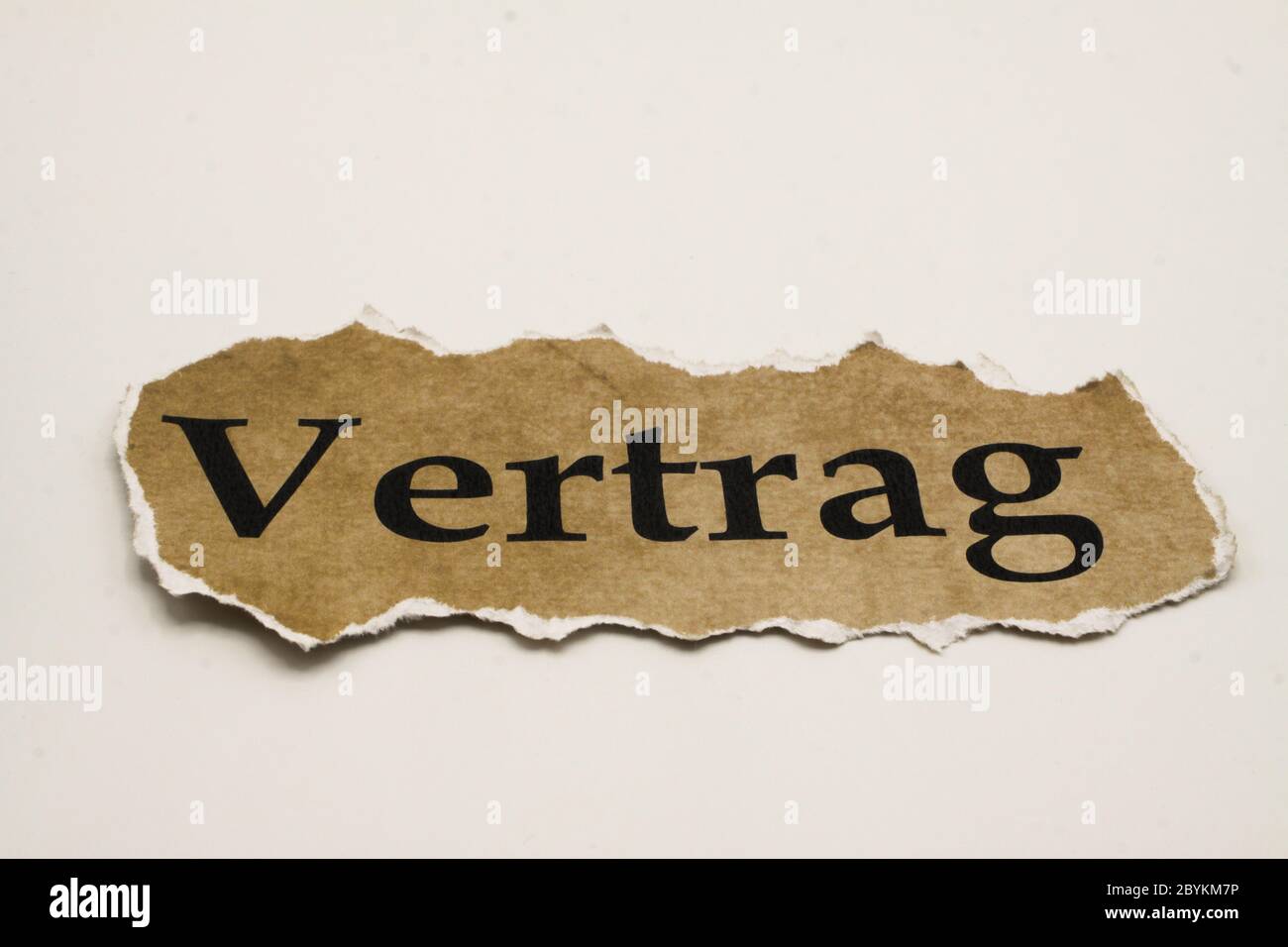 Cancelled agreement concept: Close up of isolated crumpled piece of scrap paper with word Vertrag (german word "vertrag" means contract), white backgr Stock Photo