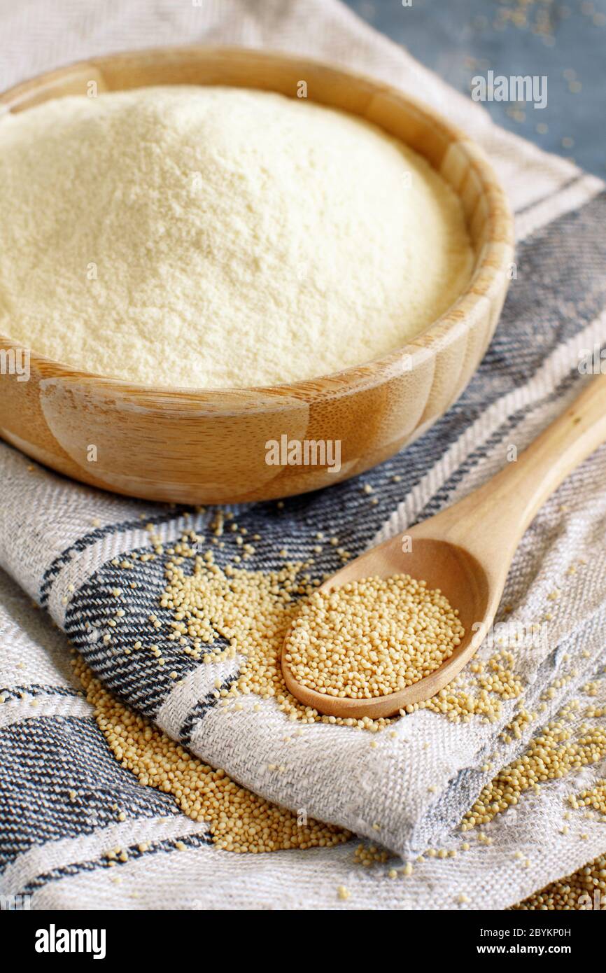 Bowl of raw Amaranth flour with a spoon of Amaranth seeds close up ...