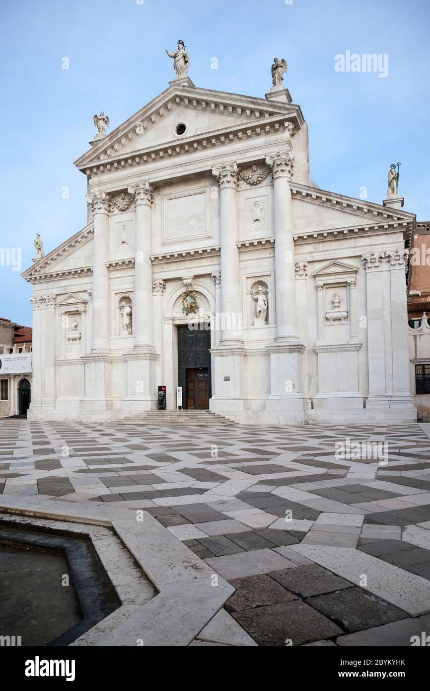 Frontal of the church of San Giorgio Maggiore in Venice, Italy with the geometrically patterned black and white marble courtyard in the foreground Stock Photo