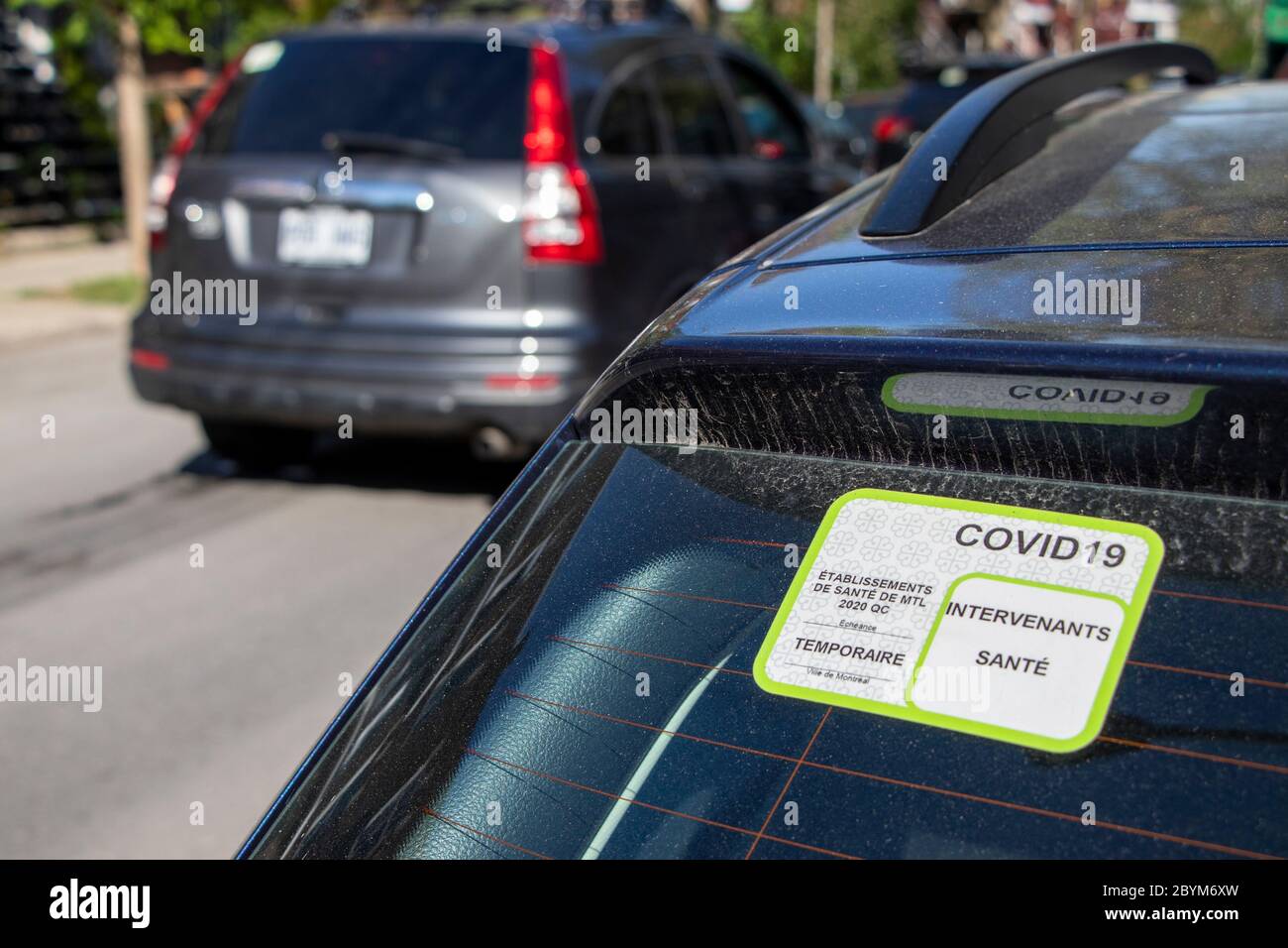May 22, 2020 - Montreal, Quebec, Canada: COVID-19 Special Parking Permit Sticker for Health worker on a car window, residential street Stock Photo