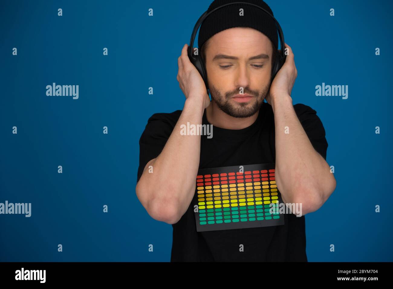 handsome Male DJ with headphones on blue Stock Photo