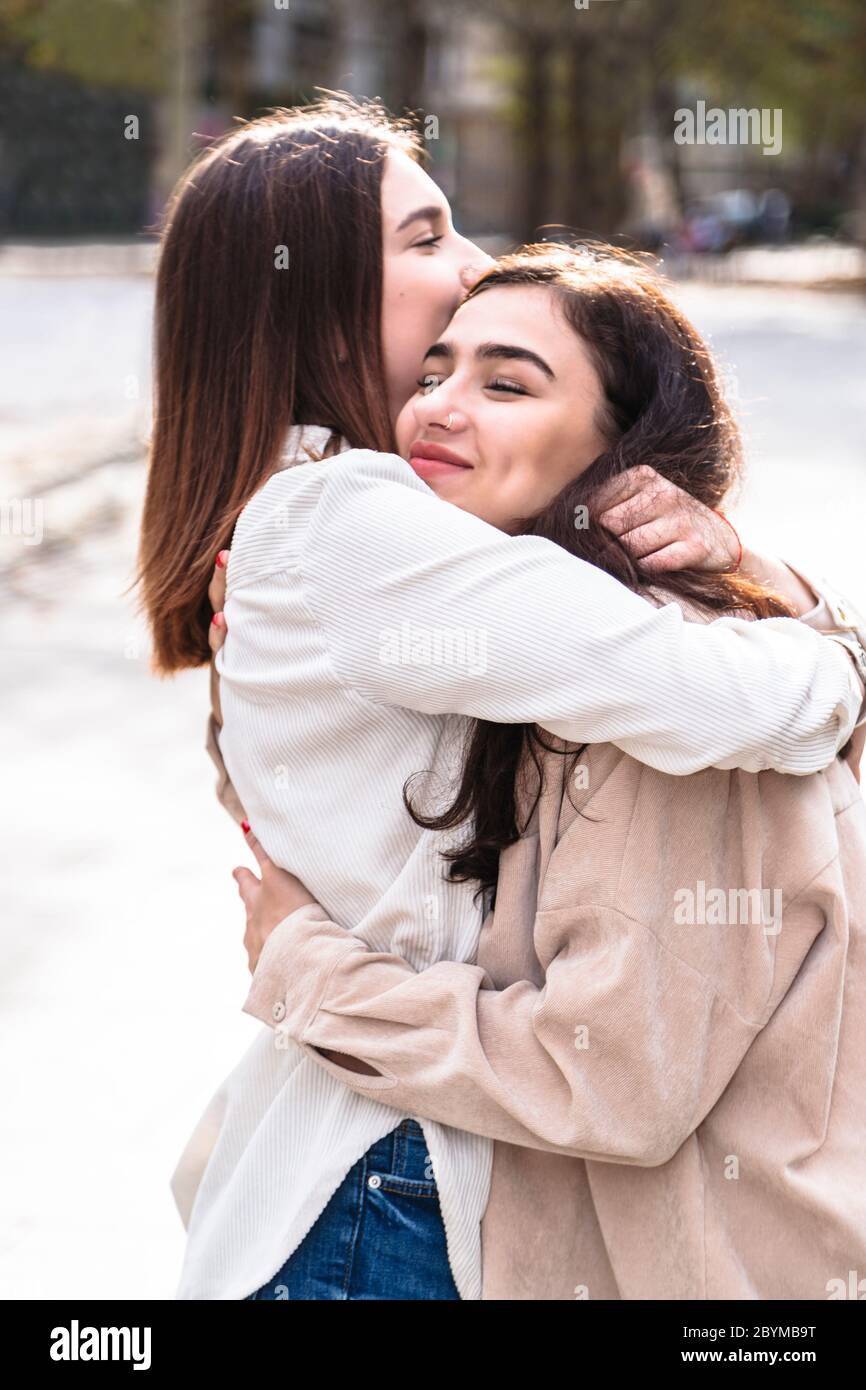 Meeting of two girls friends with hug in city Stock Photo - Alamy