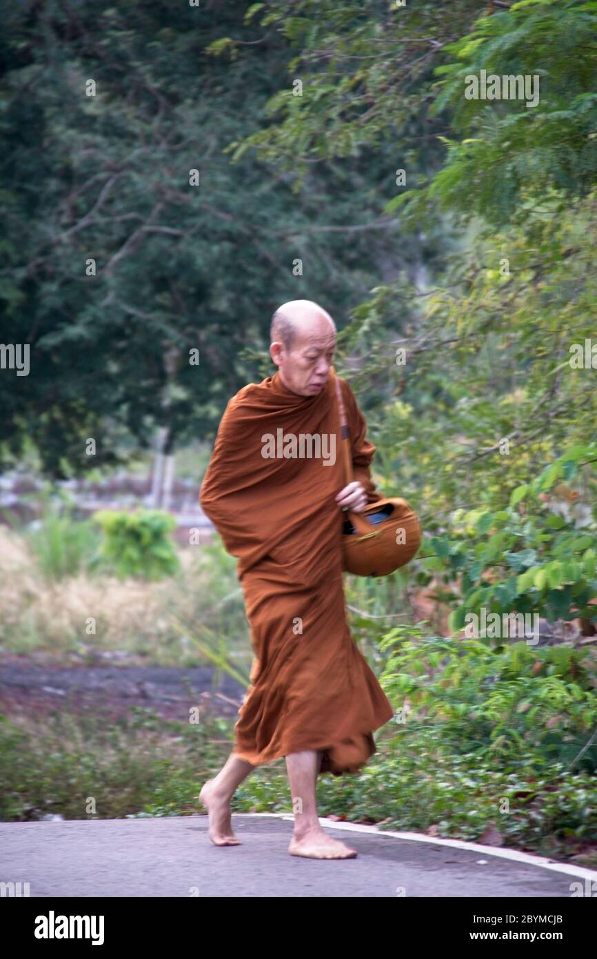 Buddhist monks walking or being transported to local village to collect food donations. Stock Photo