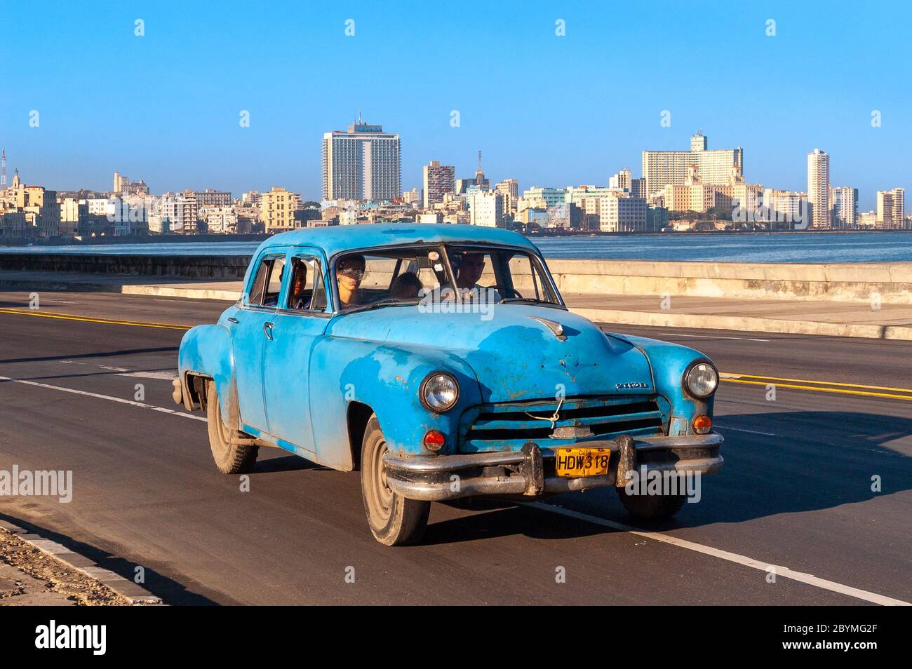 Taxi ride in a classic vintage American car driving along El Malecon, Havana, Cuba Stock Photo