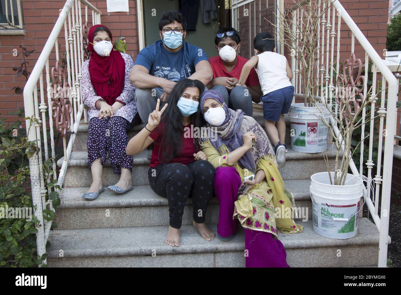 Bangladeshi Muslim family out on the front steps of their home during the Covid-19 pandemic during the holy month of Ramadan