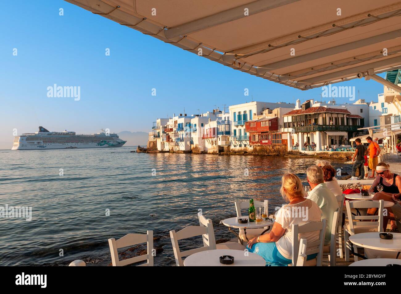 Cruise ship passengers at waterfront restaurant in the Little Venice area of Mykonos, Greece Stock Photo