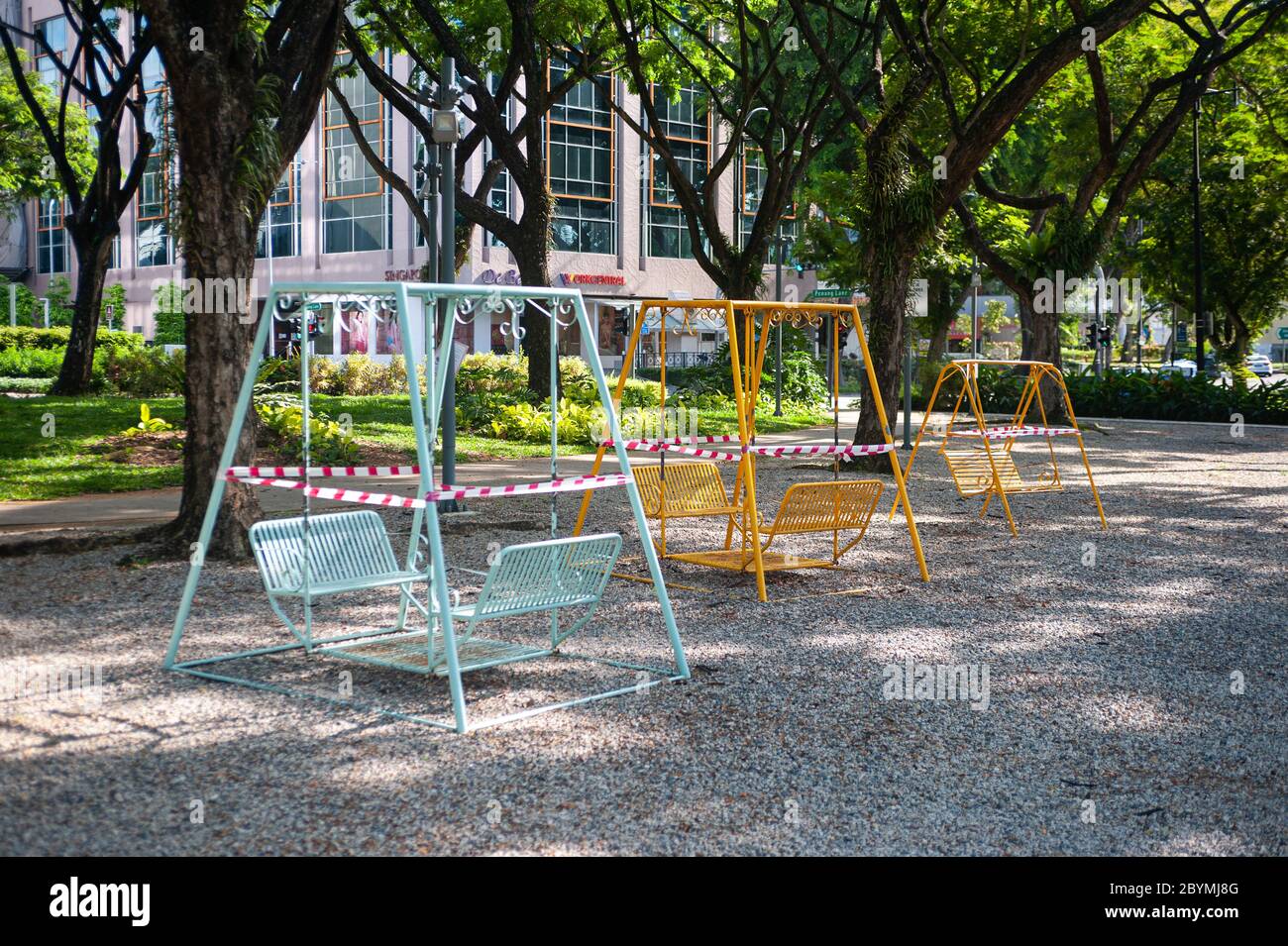 28.05.2020, Singapore, , Singapore - Swings in a small park in Dhoby Ghaut have been cordoned off with red and white tape during the exit restriction Stock Photo