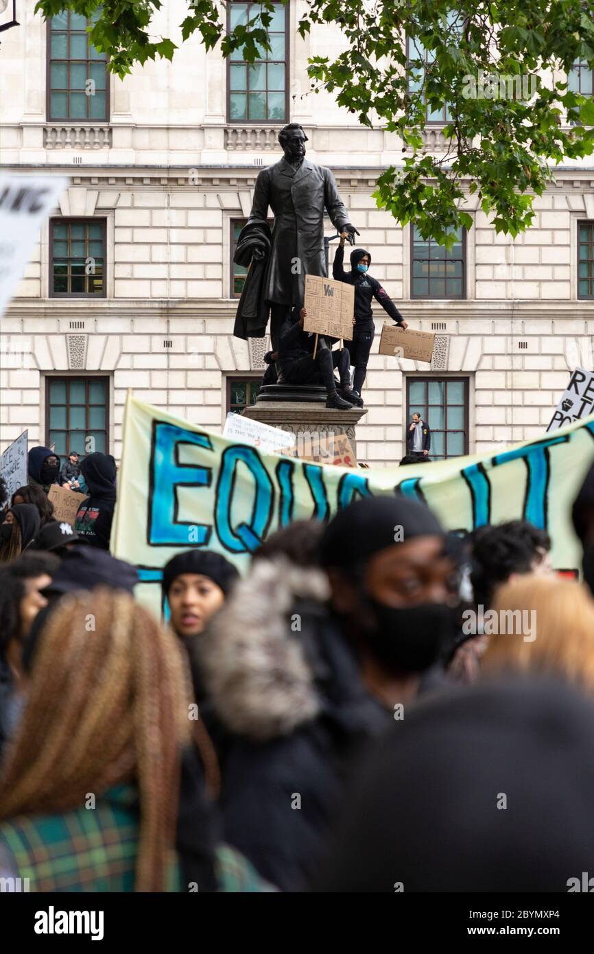 A protester stands on the plinth of a statue of the Earl of Derby during a Black Lives Matters protest, Parliament Square, London, 7 June 2020 Stock Photo