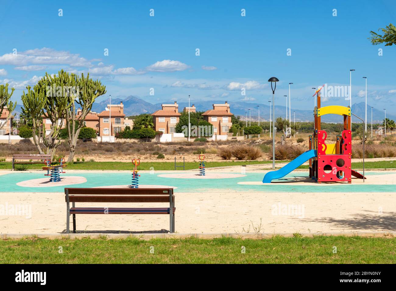 Children's playground beside new property development in town of Gran Alacant close to Alicante, Costa Blanca, Spain Stock Photo