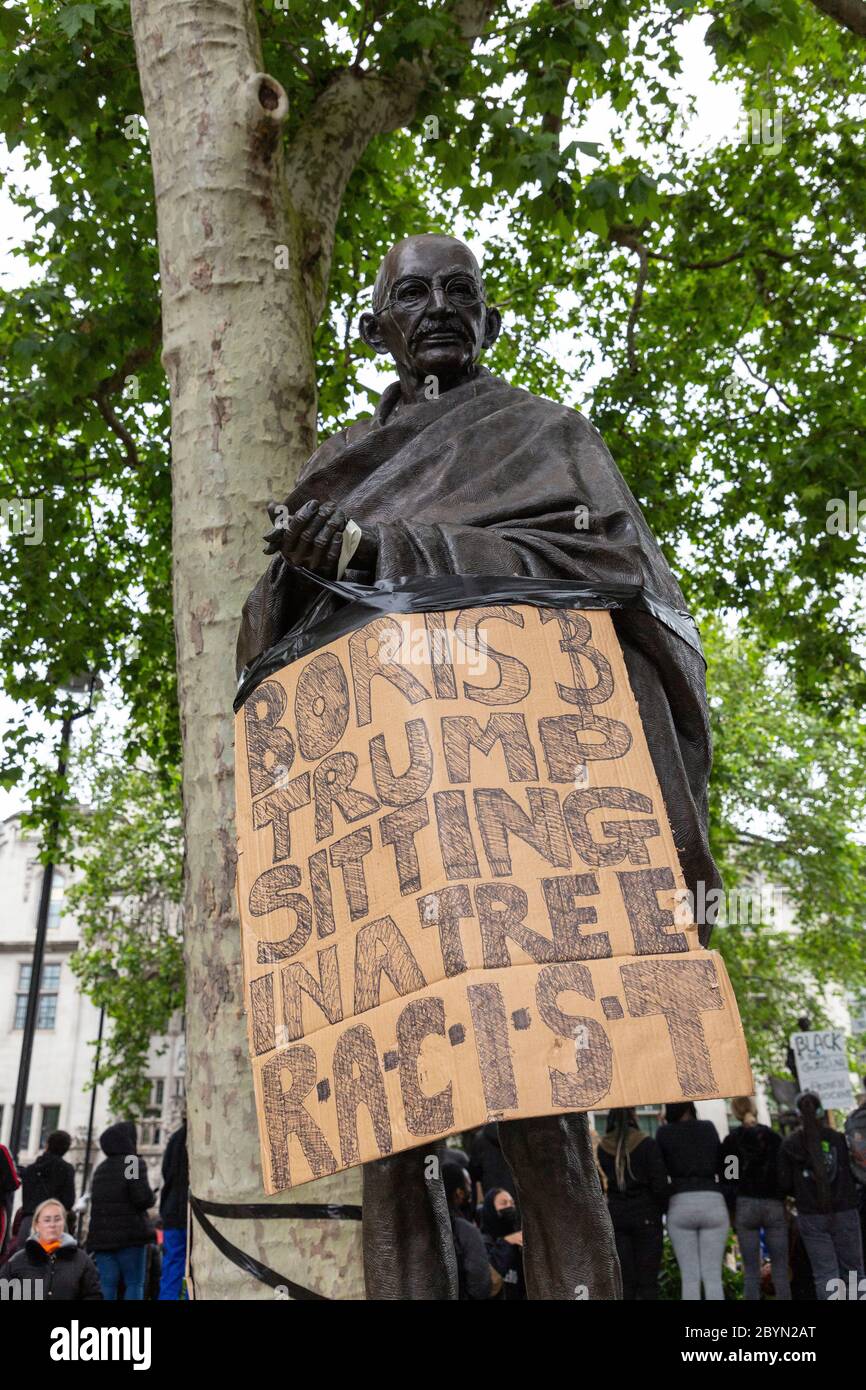 The statue of Mahatma Gandhi in Parliament Square with a sign attached, during a Black Lives Matters protest, London, 7 June 2020 Stock Photo