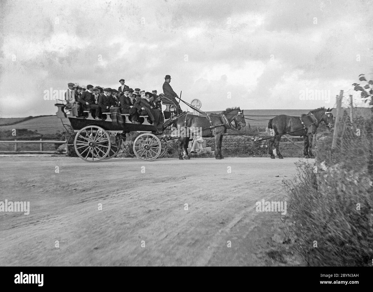 A late Victorian English vintage black and white photograph showing horses pulling a large cart with people in. This was known as a charabanc or charabang. Stock Photo
