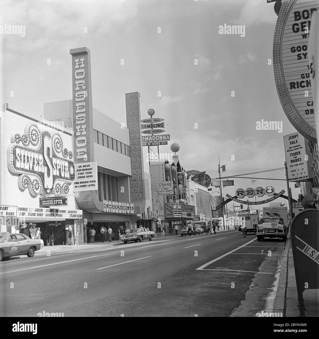 A vintage late 1960s or early 1970s black and white photograph showing the main street in Reno, Nevada, USA. Signs for casinos called The Silver Spur, The Horseshoe, The Prima Donna. Stock Photo