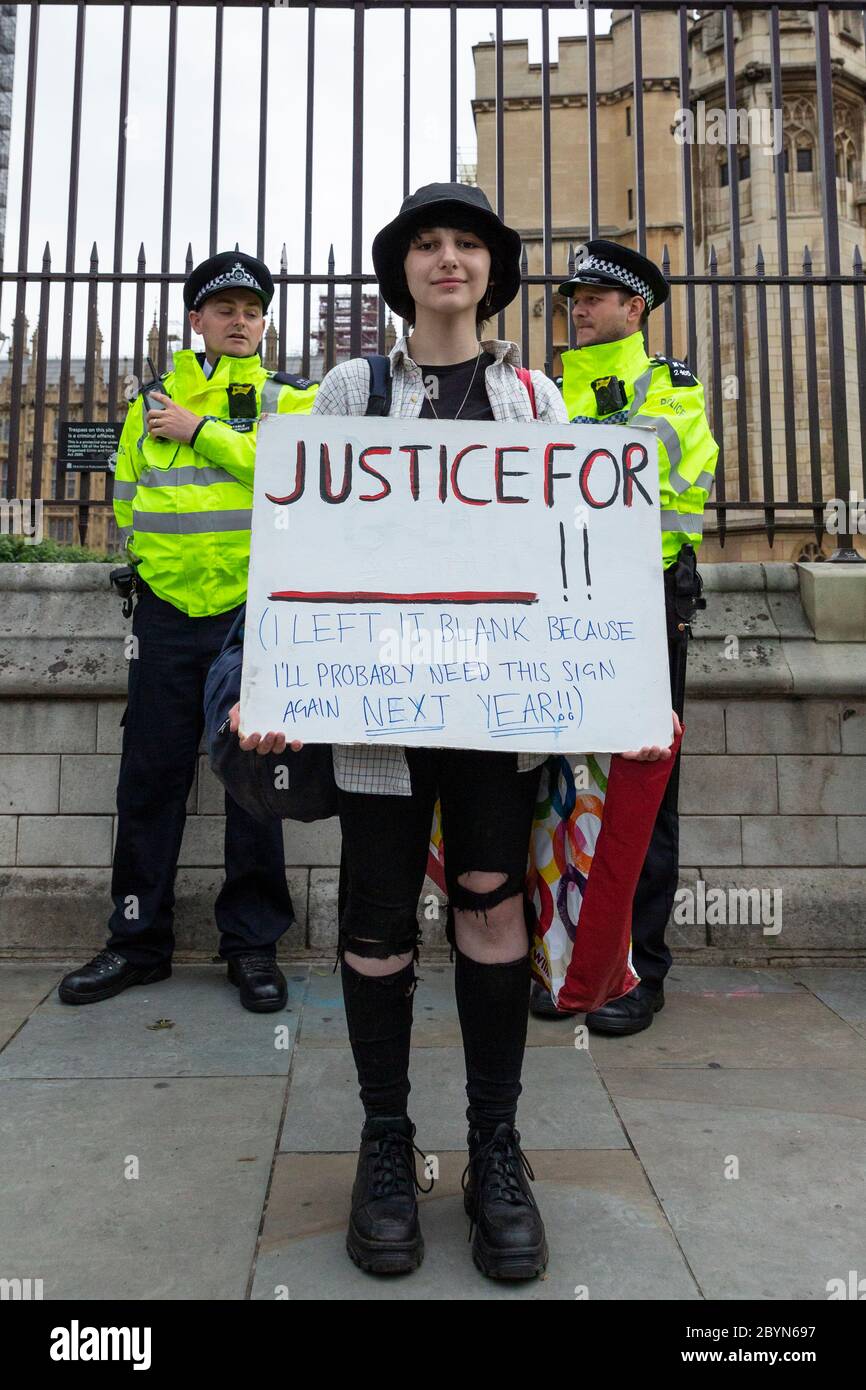 A young white girl holds a sign in front of two police officers during a Black Lives Matters protest, Parliament Square, London, 7 June 2020 Stock Photo