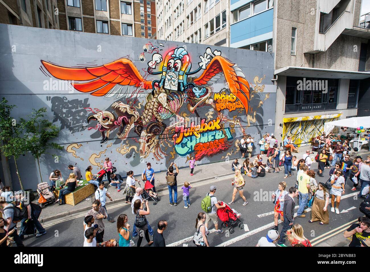 Visitors to the See No Evil Art work festival are pictured walking past urban artwork painted on the outside of buildings in Nelson Street. Aug 2012 Stock Photo