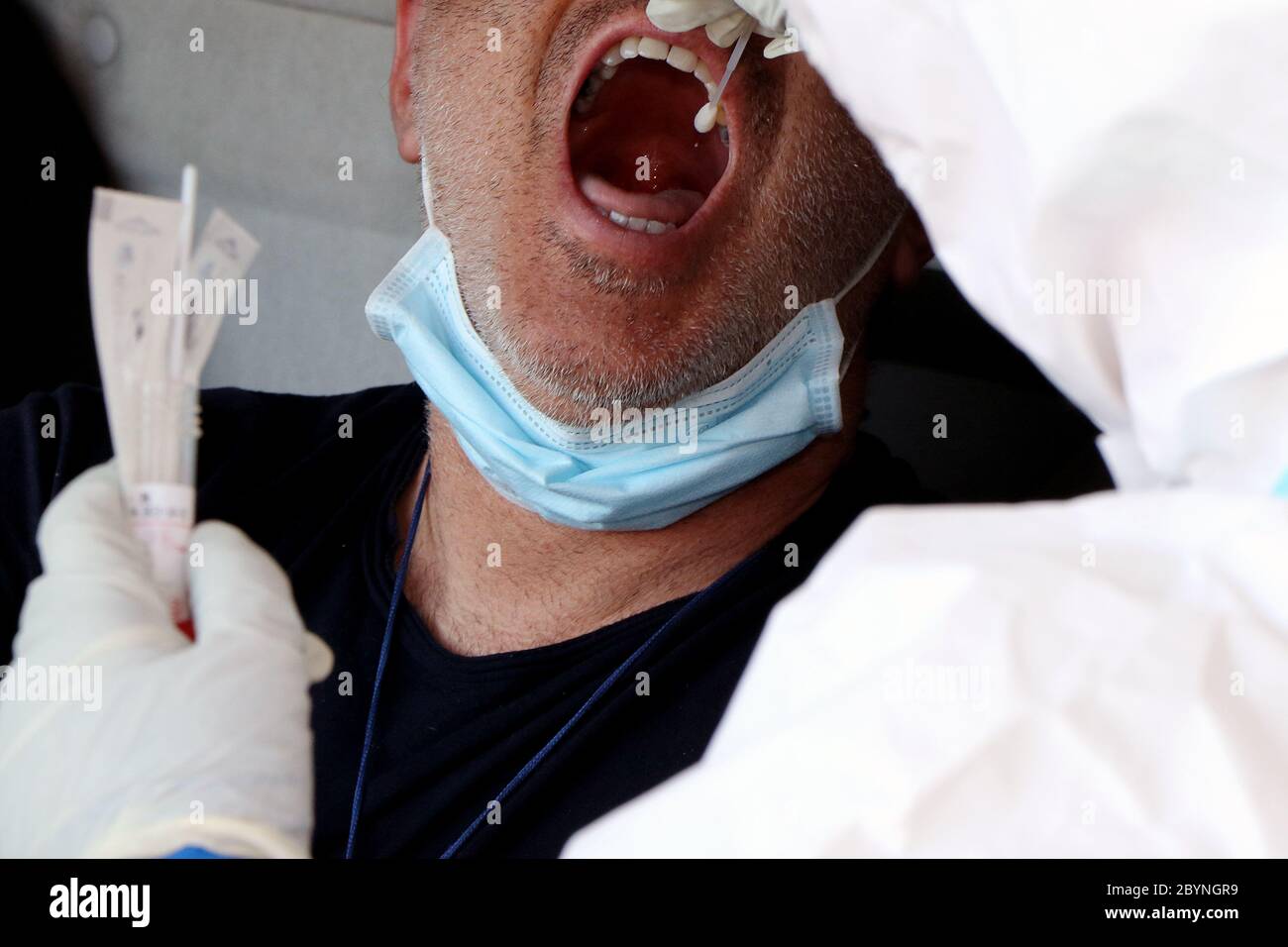 Italian nurses with protective suits, protective masks and gloves do the pharyngeal swabs to the citizens in its cars due to a possible case of corona Stock Photo