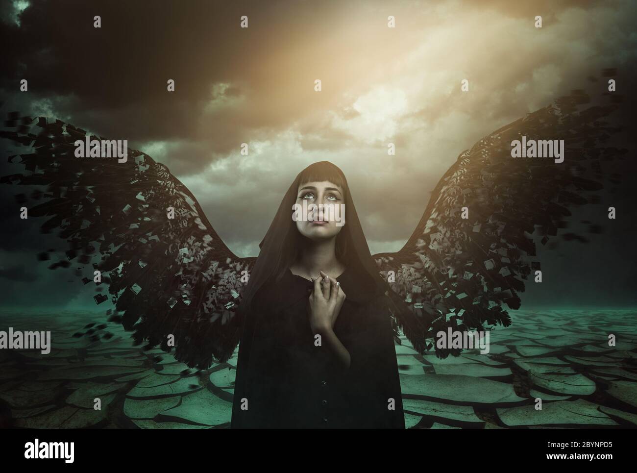 Dark angel with broken wings looks at paradise lost . Fantasy and myth Stock Photo