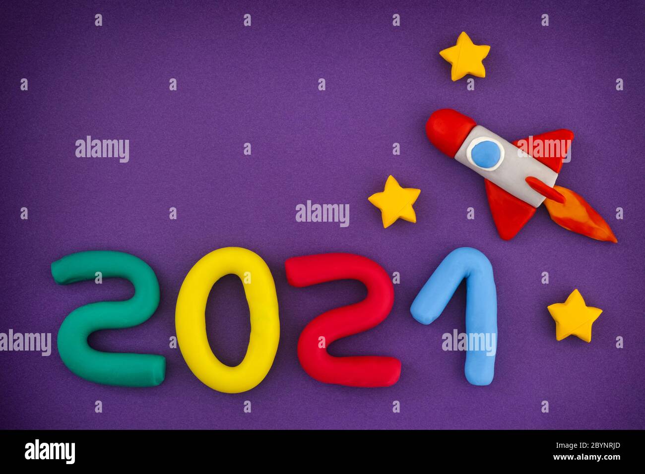 2021 New Year. Space rocket and Numbers are made out of play clay (plasticine). Stock Photo