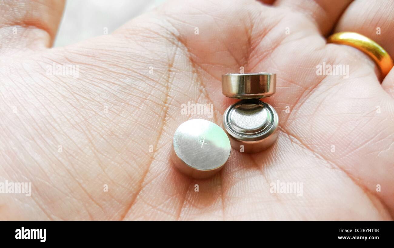 button cell battery on hand Stock Photo
