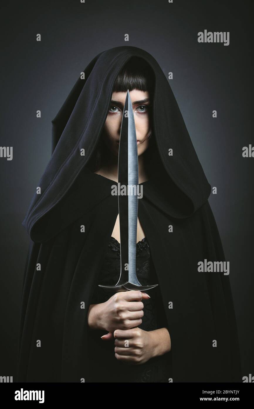 Hooded beautiful assassin. Dark fantasy Stock Photo