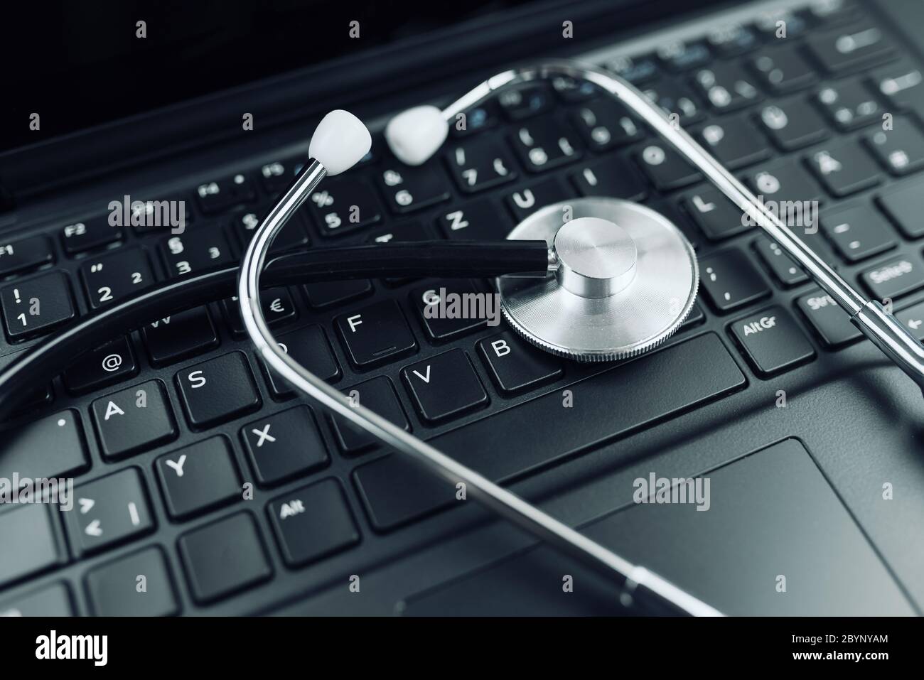 close-up high angle view of stethoscope on laptop computer keyboard Stock Photo
