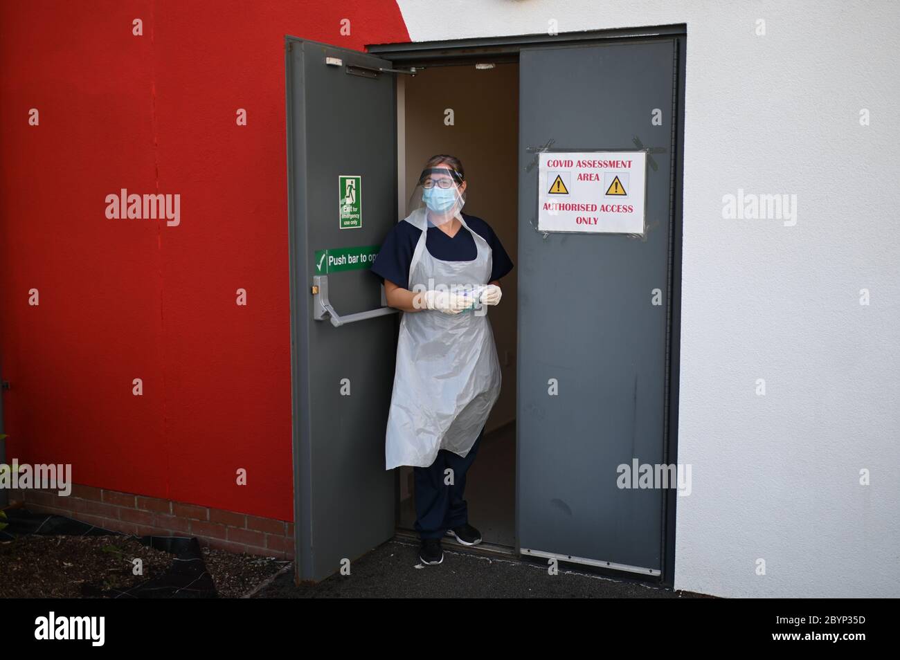 Nurse Lucy Wraith, wearing personal protective equipment (PPE), stands at a side door to test the measures taken by the practice to receive suspected coronavirus patients at Freshney Green Primary Care Centre in Grimsby, Lincolnshire. Stock Photo
