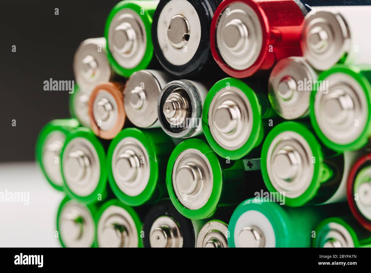 Closeup of group of used disposable AA batteries of various color. Stock Photo