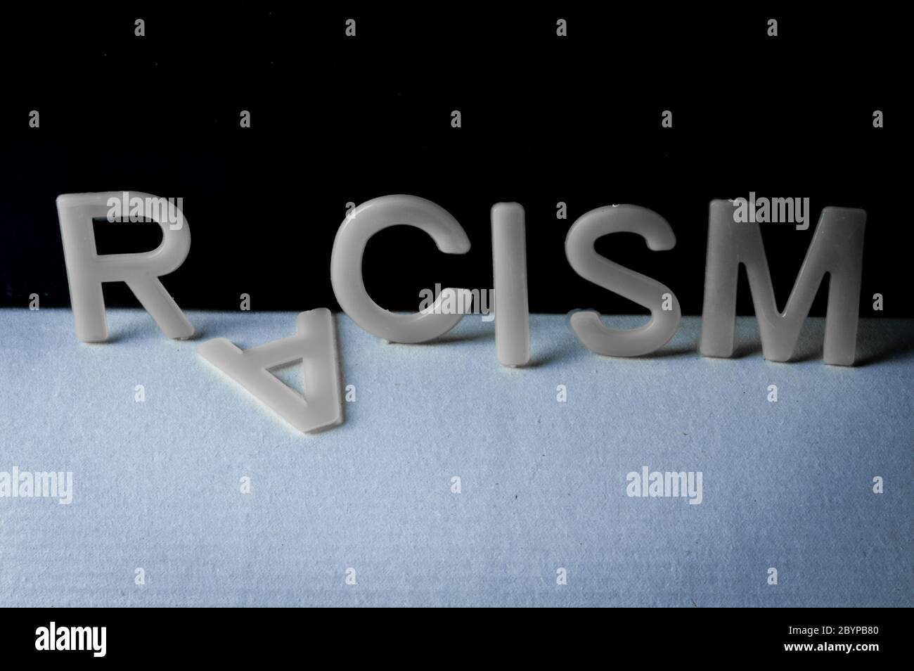 Drop racism, word written with letters on a two-tone background, the ...
