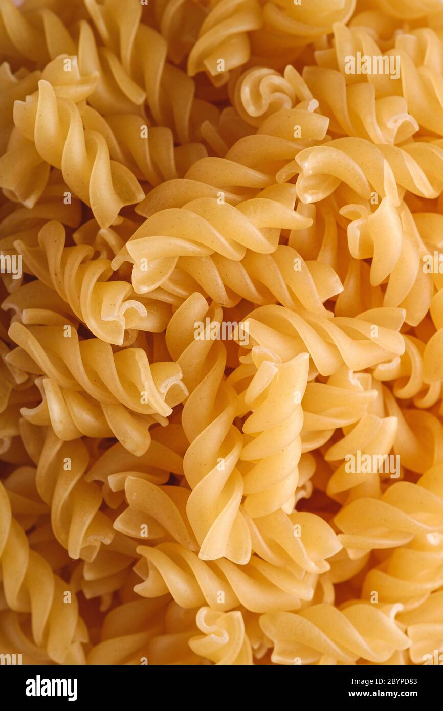 Raw wheat golden spiral pasta texture, macro top view Stock Photo Alamy
