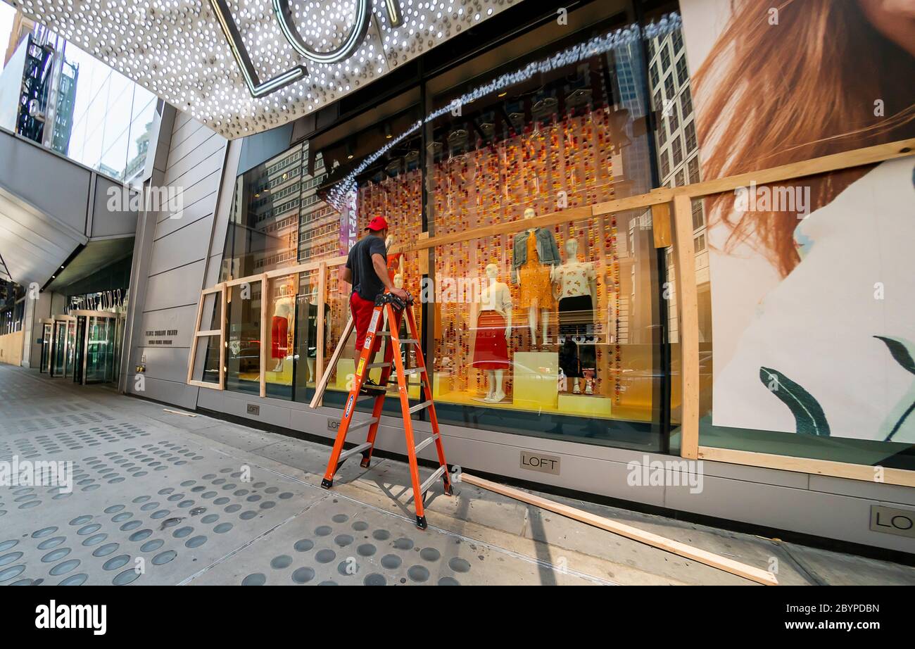 Workers remove plywood from the Loft store in Times Square in New York on Tuesday, June 9, 2020 in anticipation of reopening for curbside pick-up sales. The city officially entered Phase One of its reopening yesterday. (© Richard B. Levine) Stock Photo