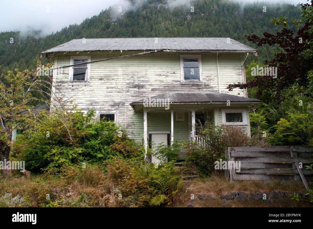 An abandoned house covered in foliage in the ghost town of Ocean Falls, in the Great Bear