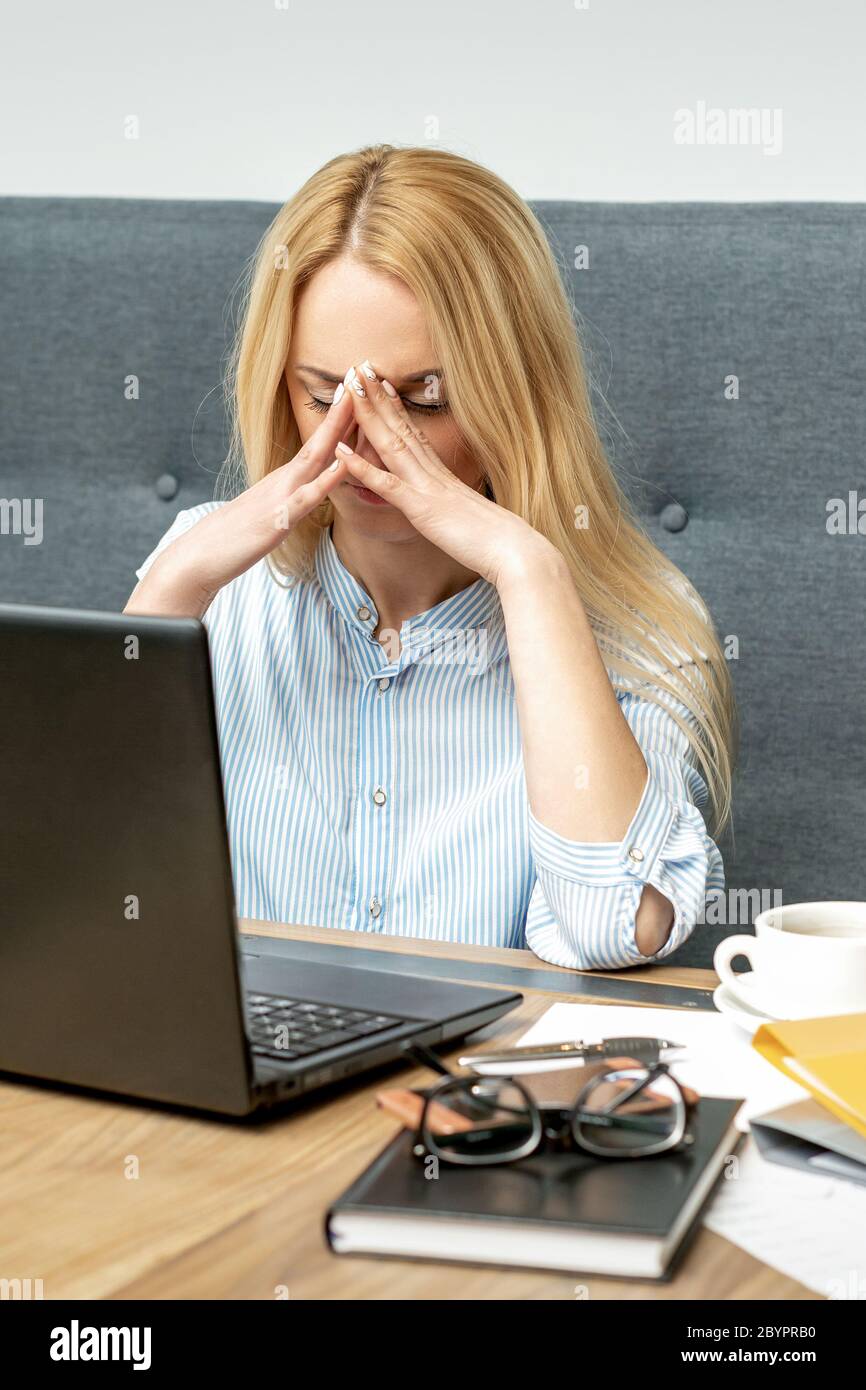 Tired young business woman sitting in front of laptop at office Stock ...