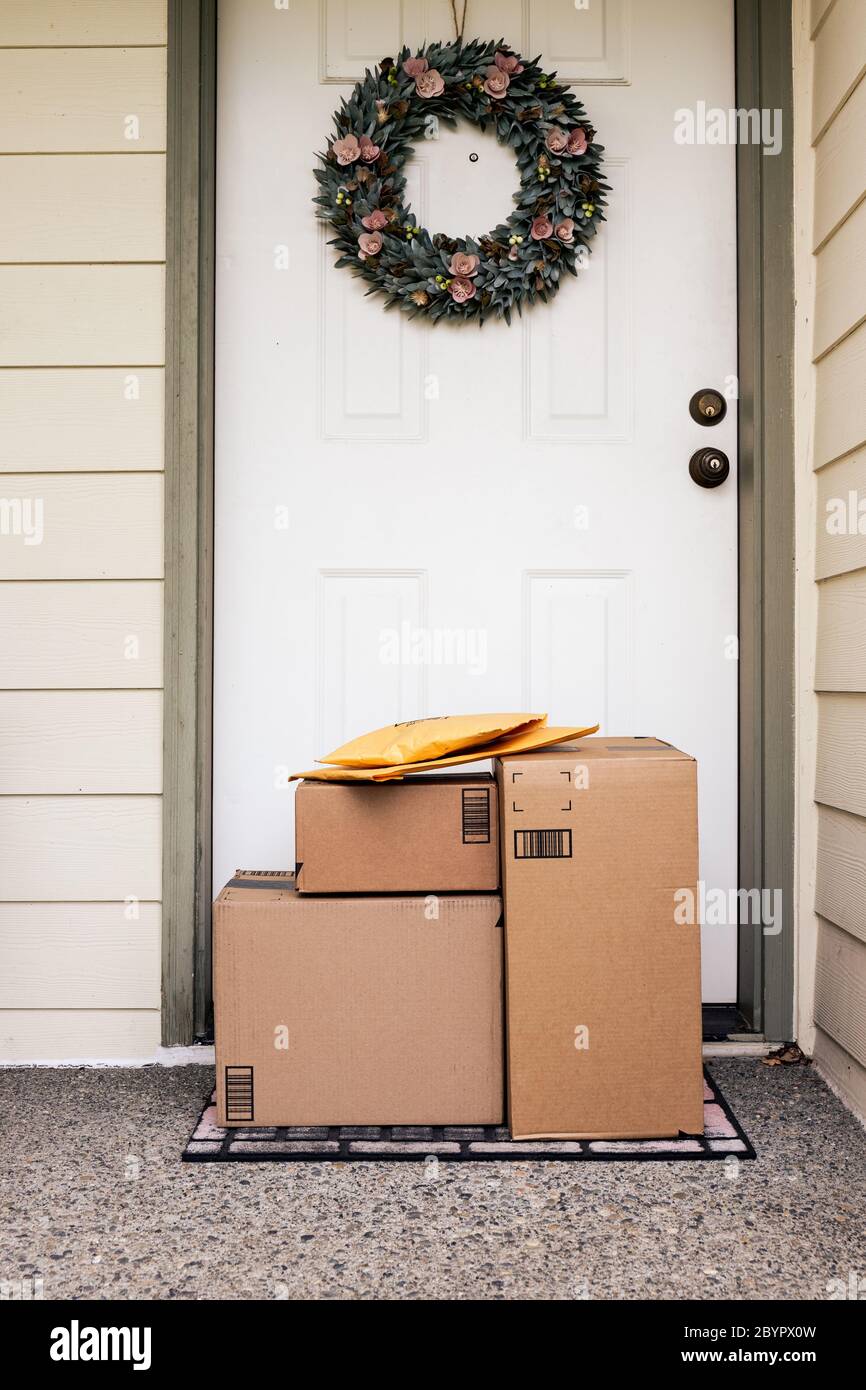 Front Door of House with Stack of Delivery Boxes from Online Ordering and E-commerce Stock Photo