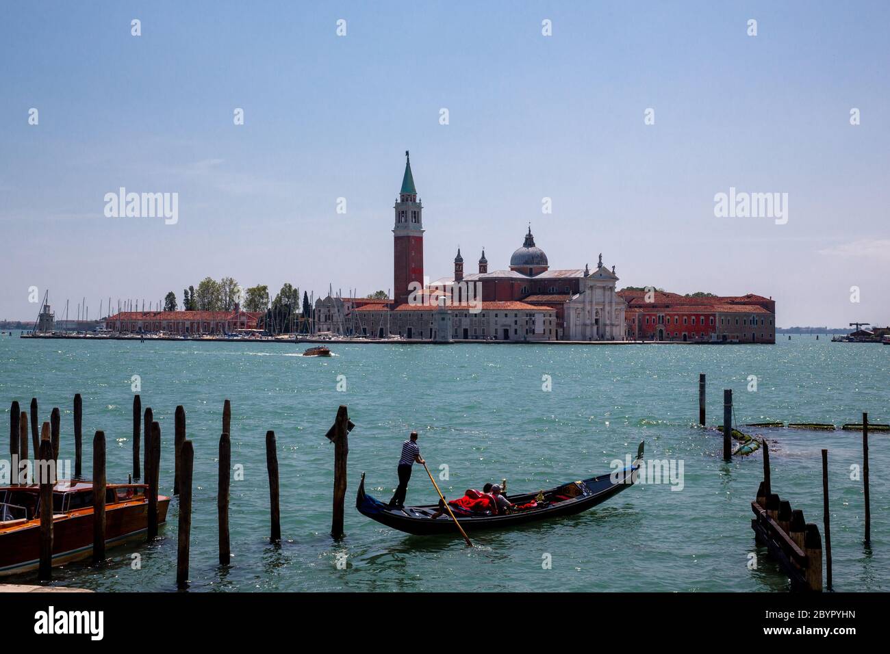 A gondolier rowing a Gondola in front of the Island of San Giorgio Maggiore, Venetian Lagoon, Venice, Italy Stock Photo