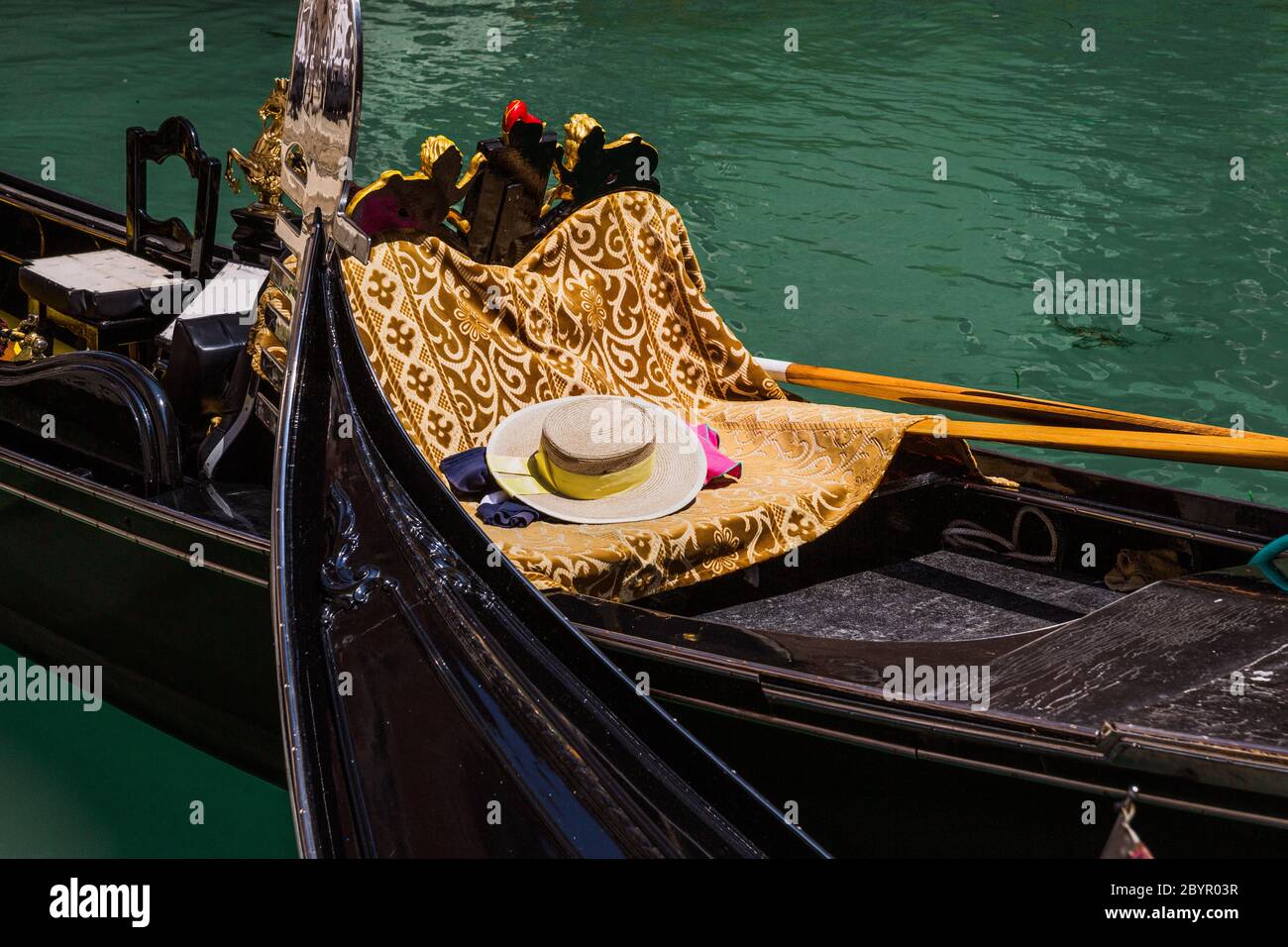 An empty traditional gondola with a gondolier's hat on it,Venetian lagoon, Venice, Italy Stock Photo