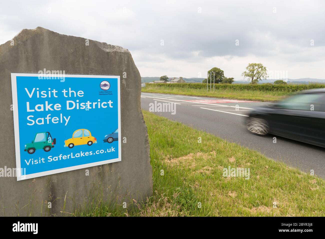 Visit the Lake District Safely sign at the entrance to the National Park  just out side Kendal .Sign put up when Government  aloud car journeys in UK Stock Photo