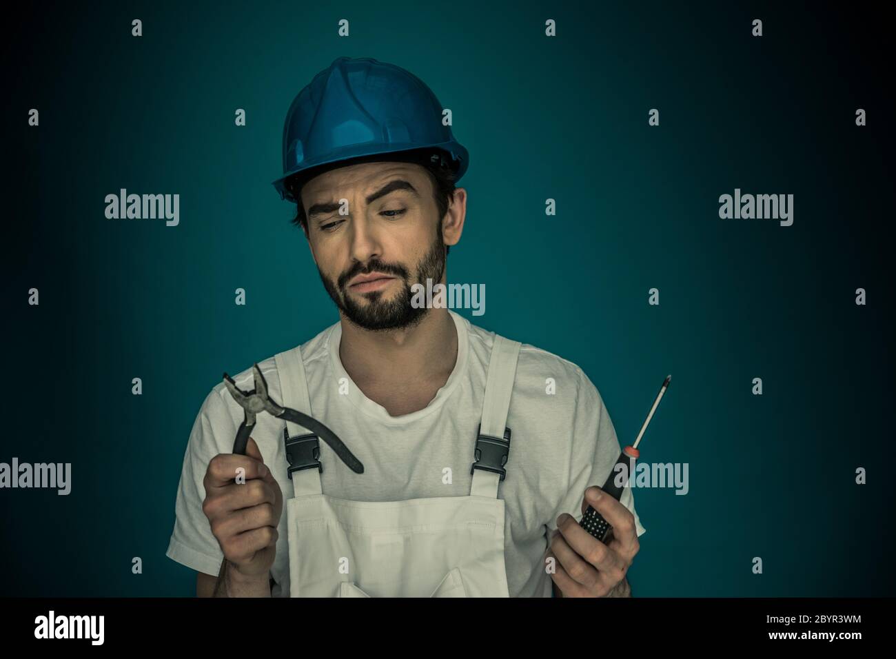 Workman standing eyeing his tools Stock Photo