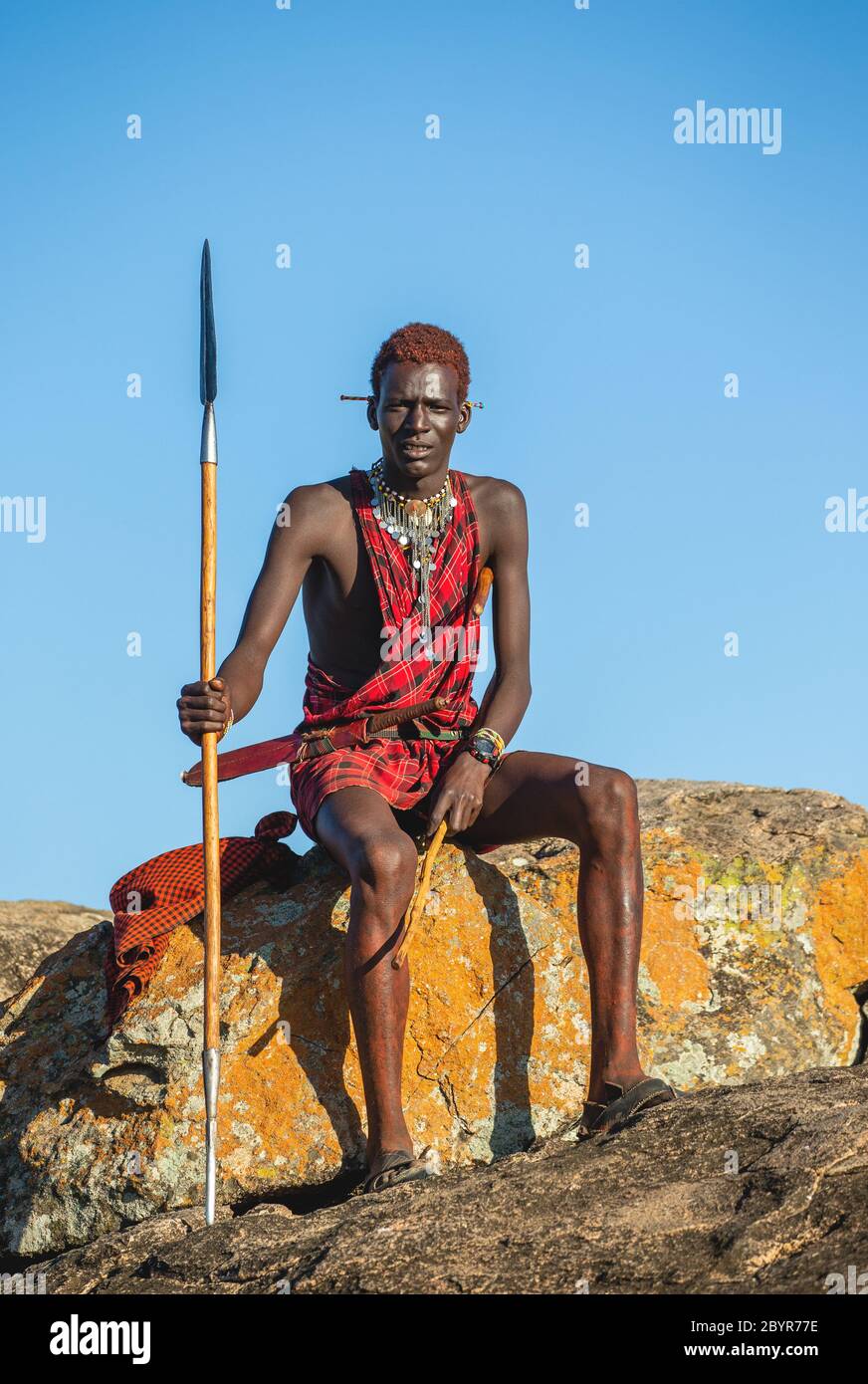 Young Masai warrior is sitting on a big 