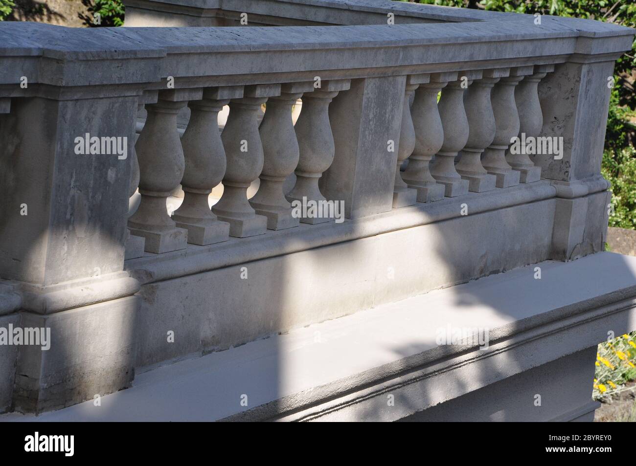 Curving white stone balustrade and railing at green environment Stock Photo