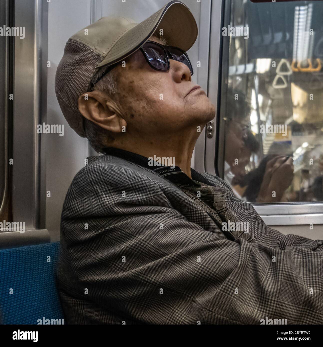 An elderly man sleeping during commuting in a Tokyo Metro underground subway train Tokyo, Japan Stock Photo