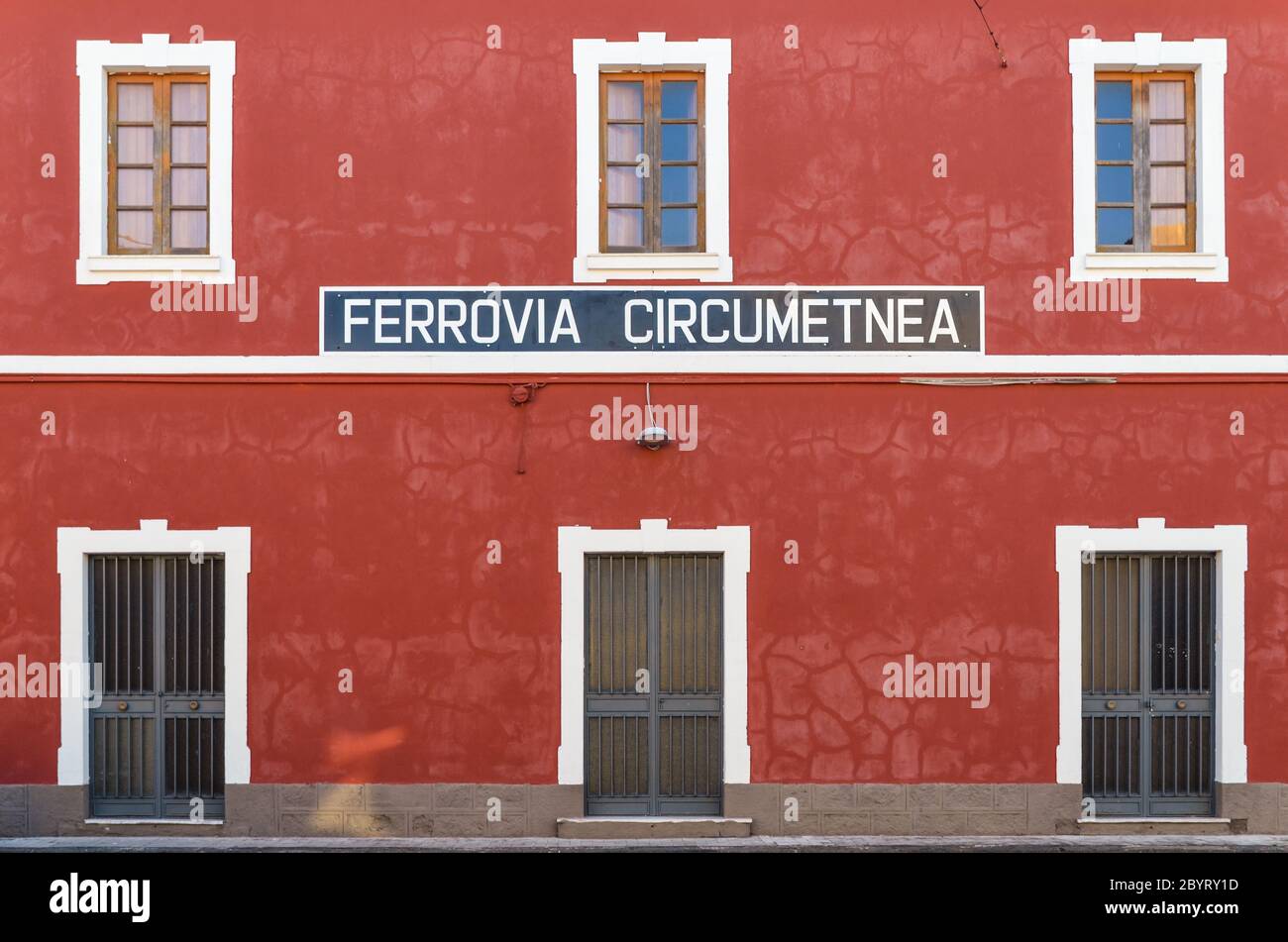 Red building and sign for the Ferrovia Circumetnea, train line around the Mount Etna, Sicily, Italy, seen in the train station of Giarre Stock Photo