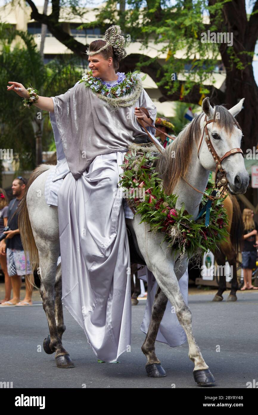 Traditional Hawaiian Pa’u Rider (model released) riding decorated horse (property released) in Kamehameha Day Parade in Kailua Kona, Hawaii. Stock Photo