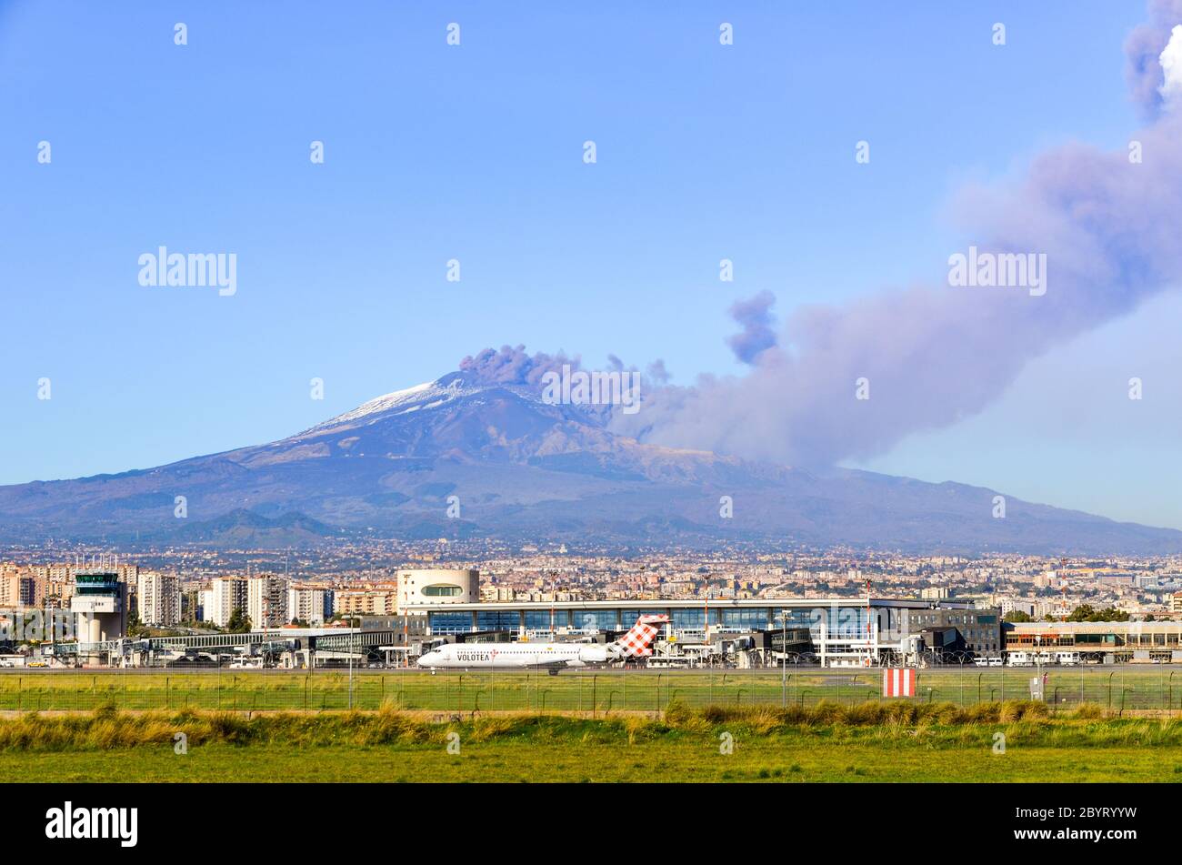Plane in taxi mode at the Airport of Catania in front of a live eruption of Mount Etna (Sicily, Italy) on the 24th December 2018 Stock Photo