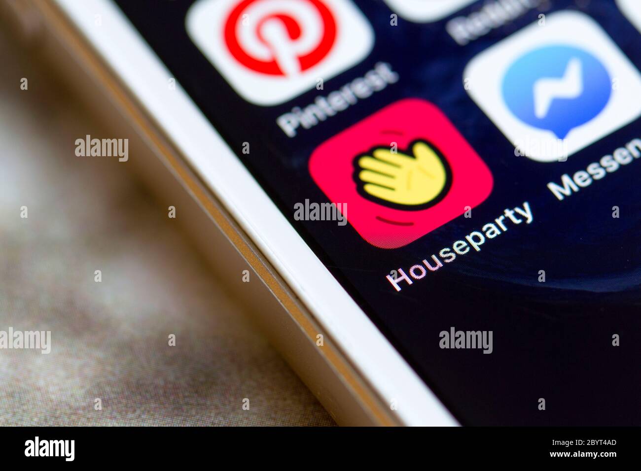 Houseparty mobile app icon is seen on a smartphone. Houseparty is a social networking service that enables group video chatting. Stock Photo