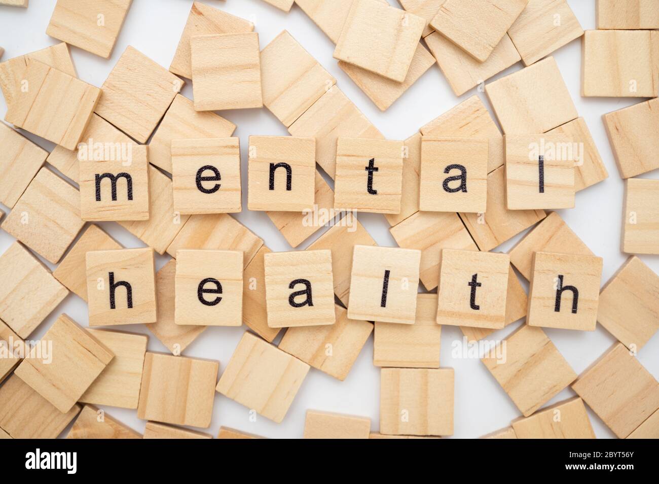 Generic wooden scrabble tiles isolated on white background spelling the word MENTAL HEALTH Stock Photo