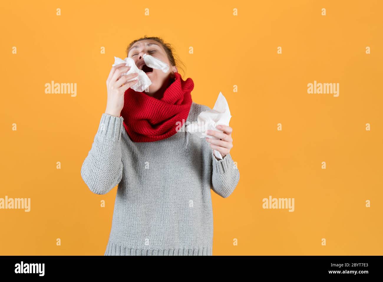 sick girl with napkins in her hands sneezes, throwing her head back