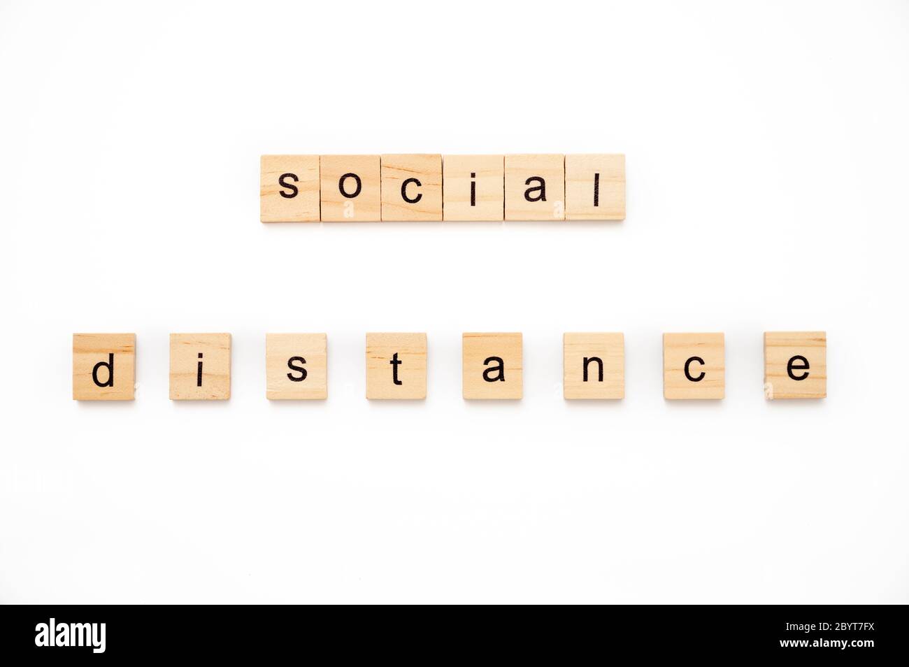 Generic wood scrabble tiles spelling words Social Distance Stock Photo