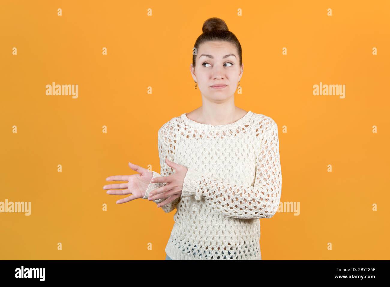 The girl holds out her hands to take something, but looks doubtful Stock Photo