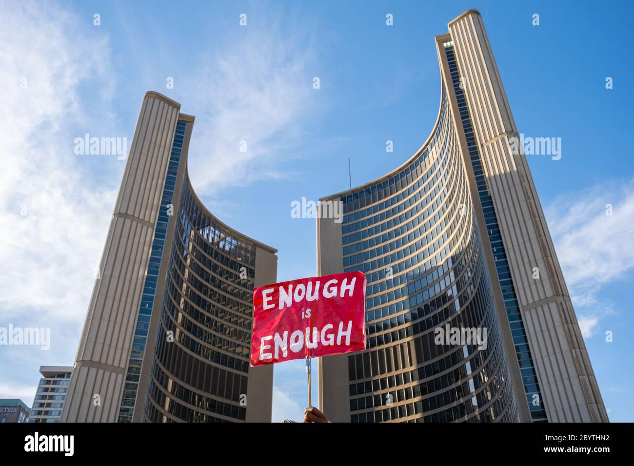 A protester holds a sign stating 'Enough is Enough' outside of City Hall during a Black Lives Matter protest at Nathan Phillips Square in Toronto. Stock Photo